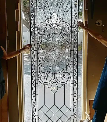 Clear bevelled and leaded glass door panel held in place during installation